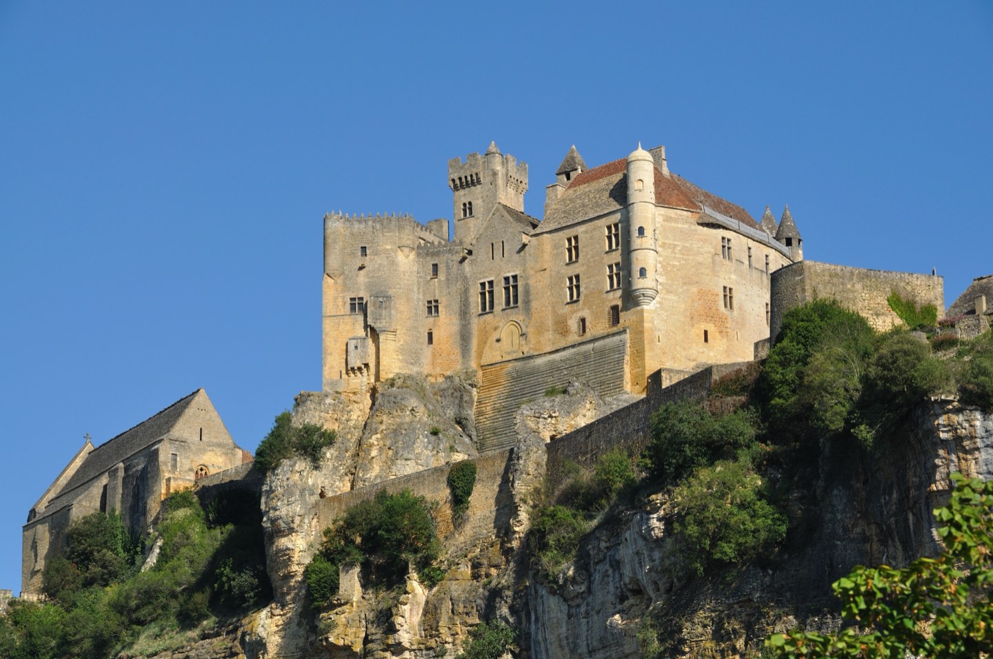 Château de Beynac standing above stone buildings and the Dordogne landscape.