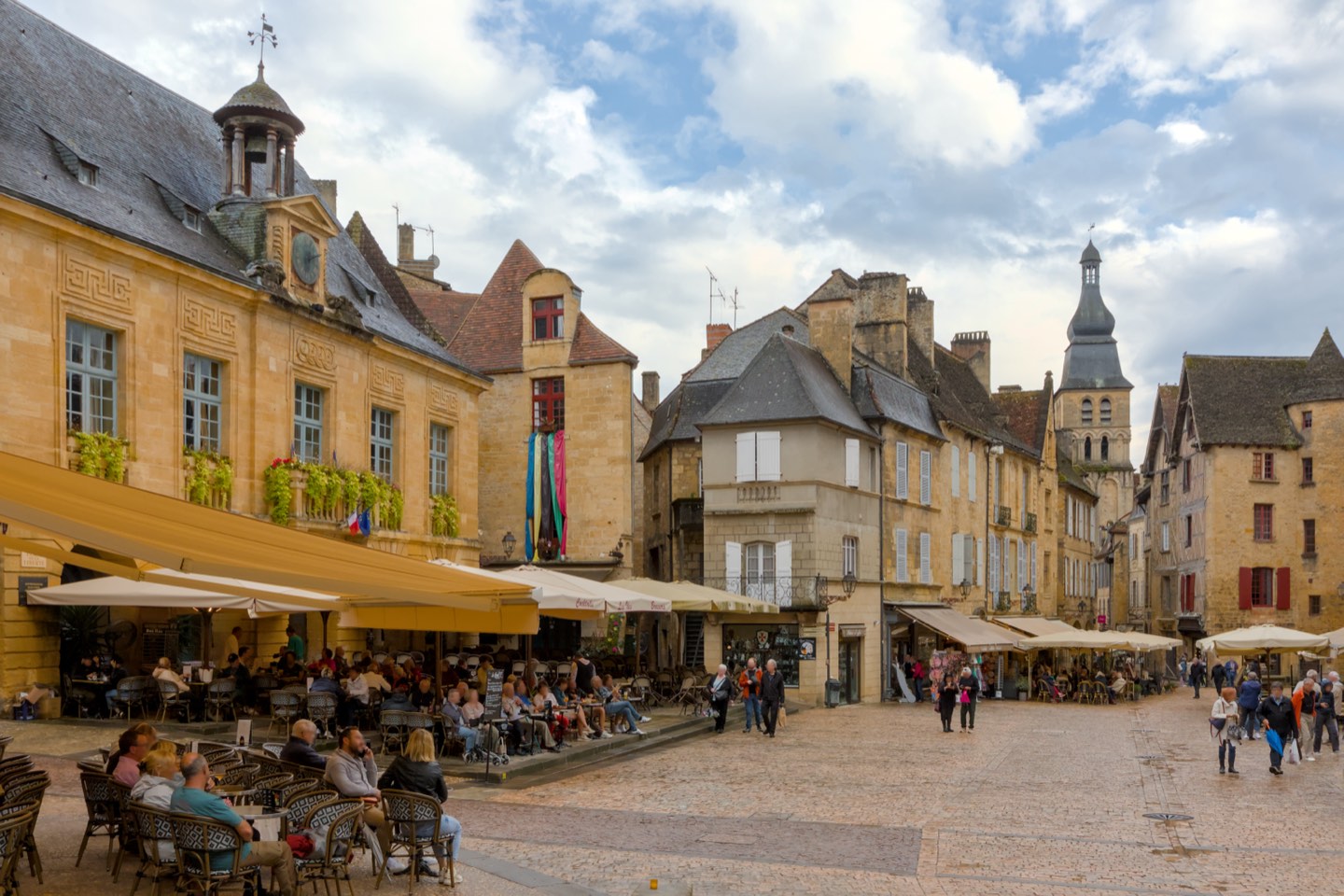 Place de la Liberté in Sarlat-la-Canéda with historic stone buildings and market square.